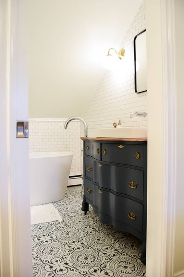 Polished chrome fixtures with freestanding tub and patterned floor tile