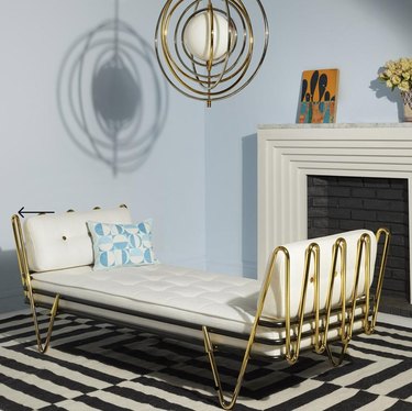 Small Space Daybed Ideas with Brass daybed, striped rug, brass pendant lamp, mantle.