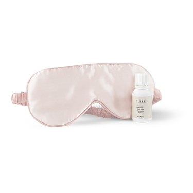 pink eye mask and essential oil blend in white bottle