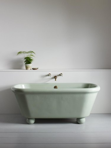modern bathtub fixtures with green tub in a gray room