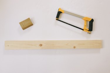 1x4 wood board cut with hacksaw next to sanding sponge