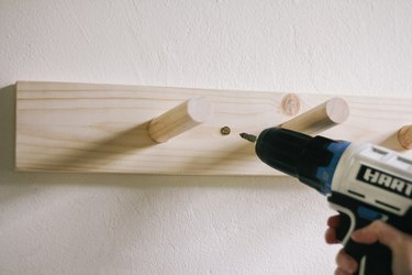 Drilling screw through peg rail and into wall