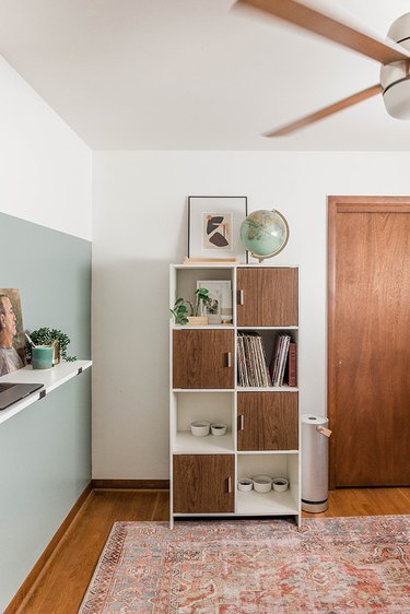 Midcentury modern home office with green and white walls and a modern shelf