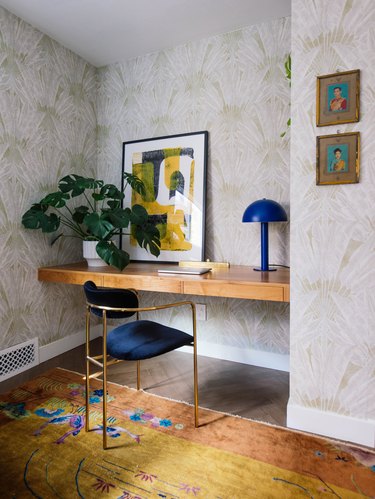 Midcentury modern home office with blue velvet chair and modern blue desk lamp