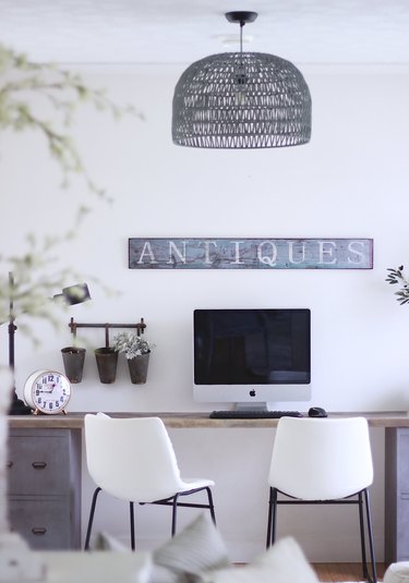 Farmhouse home office with vintage sign and black woven chandelier