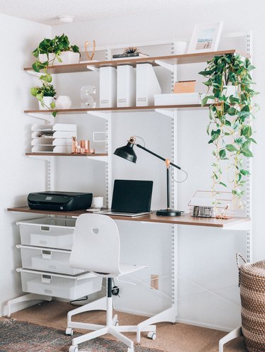 white modern home office with modular wall mount system featuring a desk and shelving