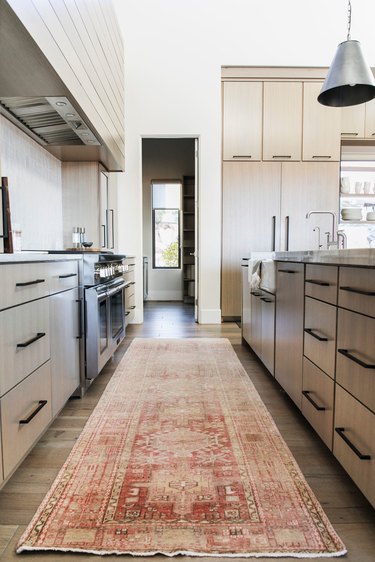 Modern cookspace with wood flat panel kitchen cabinets and black pulls