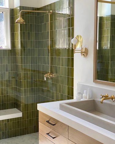 brass shower fixtures with vertically stacked green tile