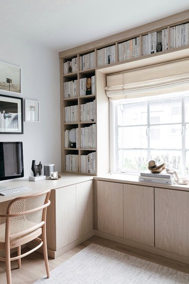 white modern, Scandinavian home office surrounded by light wood built-ins