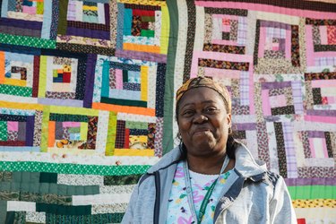 woman standing in front of quilt