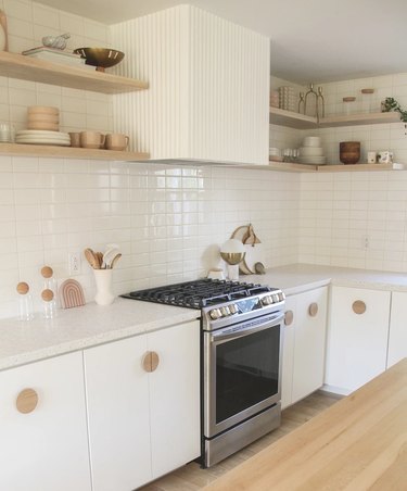 Modern cookspace with white flat panel kitchen cabinets and geometric pulls