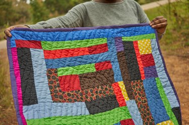 woman holding colorful quilt