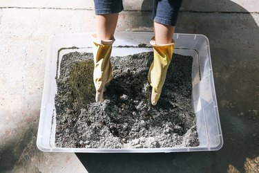 Mixing hypertyfa ingredients in plastic storage bin with gloved hands