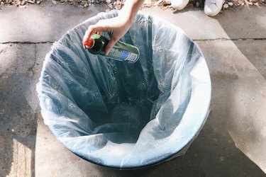 Spraying cooking oil into planter pot lined with plastic