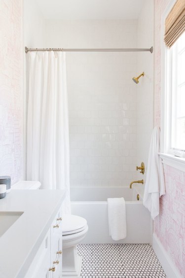 traditional shower fixtures with white wall tile and pink wallpaper