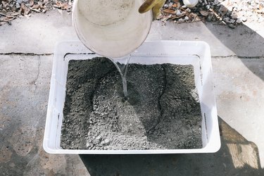 Pouring water into storage bin with hypertufa mix