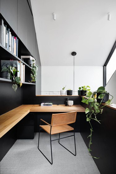 black home office in a landing nook with wood wall mount wrap-around desk