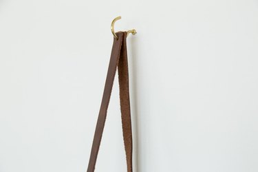 leather strap hanging from hook on wall