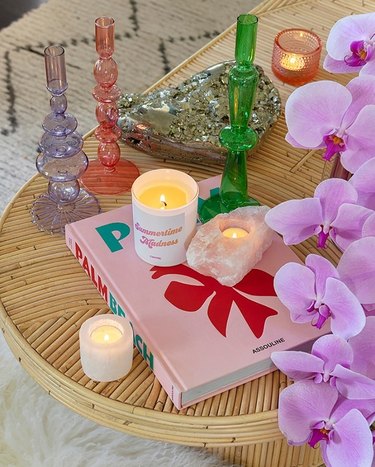 coffee table decorated with colorful candles, books, and flowers