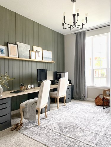 Green home office with shiplap accent wall and double workspace