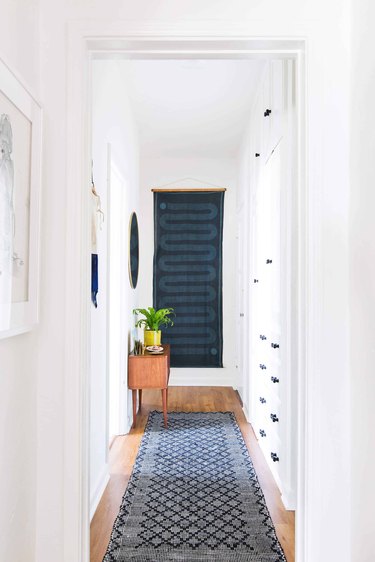 Hallway Focal Point Ideas in white hallway with vintage runner and boho wall tapestry