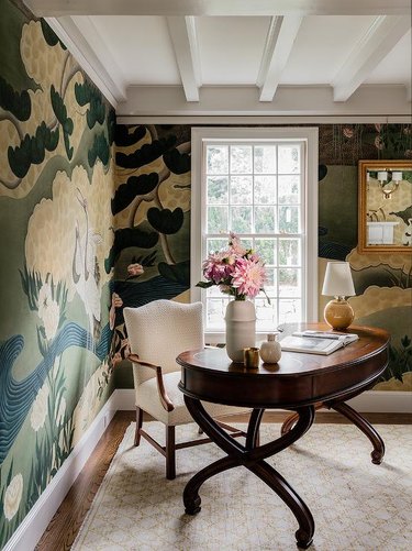 traditional home office with oval desk and mural wallpaper