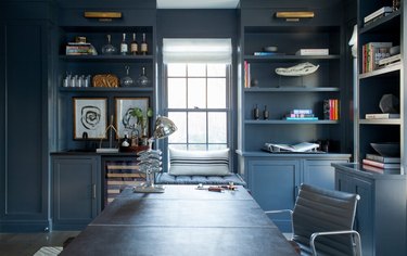 steel blue home office with built-ins and window in the middle of the room