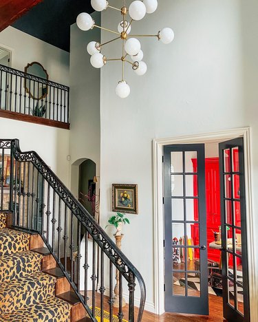 Sarisa Munoz The Indigo Leopard Home staircase with leopard print runner and globe style chandelier