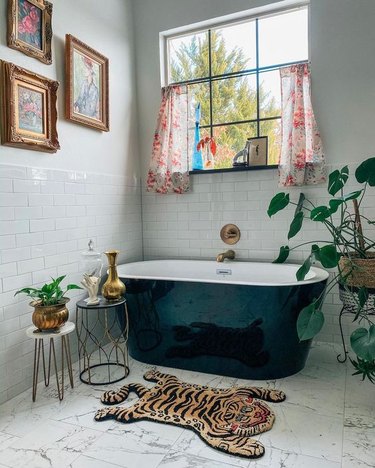 Sarisa Munoz The Indigo Leopard Home bathroom with red floral chandelier and black freestanding tub