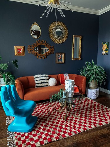 navy blue living room with burnt orange sofa