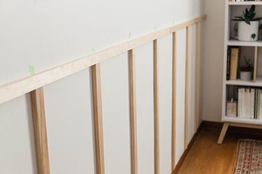 Nail the vertical slats to the wall.