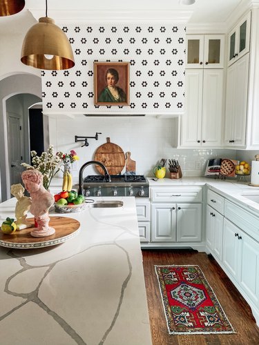 Sarisa Munoz The Indigo Leopard Home kitchen with white cabinets brass pendants