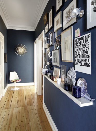 Hallway Gallery Wall Ideas with prints, art, shelf, accent chair, wood floor.