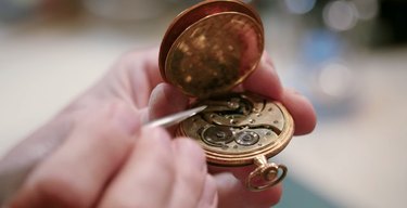 the repair shop clock restorer repairing a wartime pocket watch