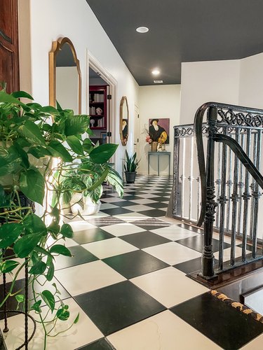 Sarisa Munoz The Indigo Leopard Home hallway with black and white checkered floor tile and potted plants