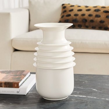 ivory sculptural vase near white couch