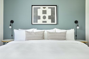 White bed against sage green wall