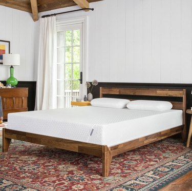 mattress on wood bedframe in bedroom