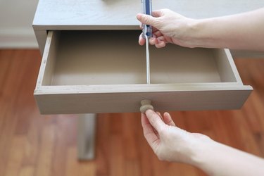 Removing drawer knob on desk with a screwdriver