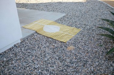 Yellow and white striped eco-friendly rug laying on ground in desert