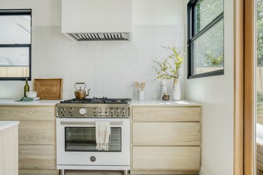 All-white modern kitchen in Los Angeles with stove vent