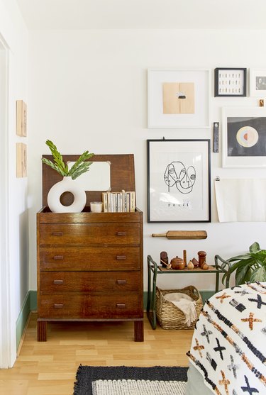 book storage in midcentury bedroom with a stack of books on top of a dresser.