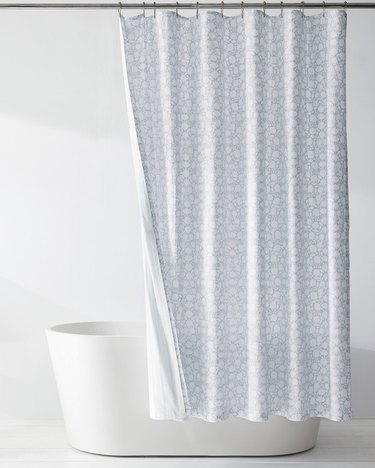 Blue and white floral reversible eco-friendly shower curtain in white bathroom