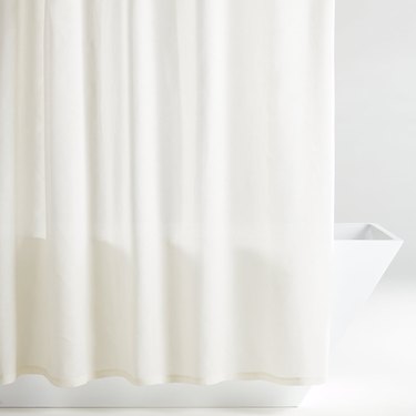White hemp eco-friendly shower curtain in white bathroom with bathtub