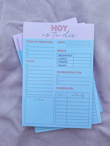 notepads with text "hoy es tu dia"