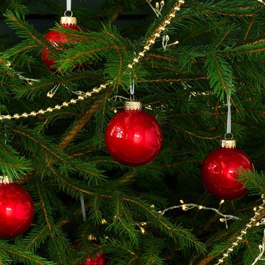 close-up of christmas tree with garland and red ornaments