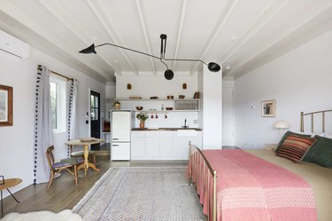 white converted garage bedroom idea with pink bedding and black pendant light