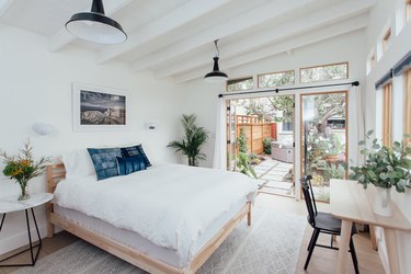 white converted garage bedroom idea with bed and wall of windows