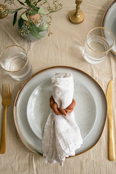 Plate setting with linen napkin inside a DIY twisted clay napkin ring