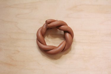 Twisted terra cotta clay log formed into a napkin ring shape